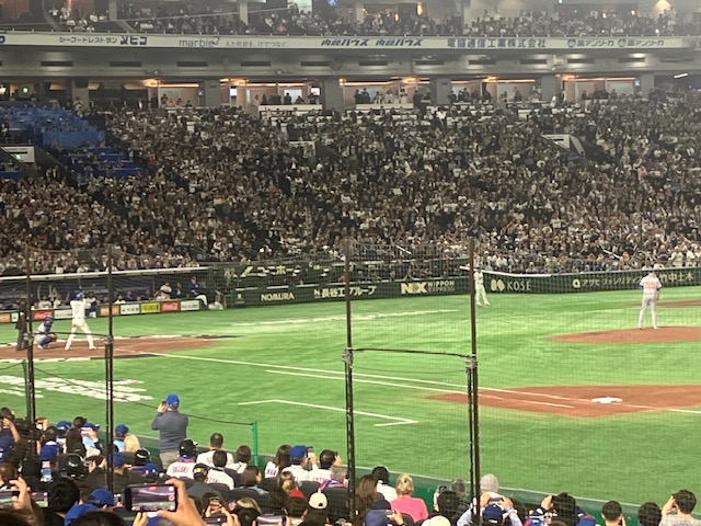 東京ドームで行われている野球の試合の風景。観客で埋まったスタンドとフィールドが見える。